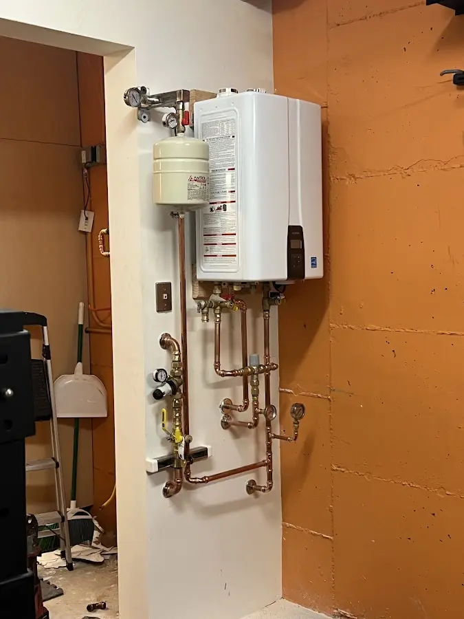 Plumbing technician inspecting water heater connections in Villa Rica